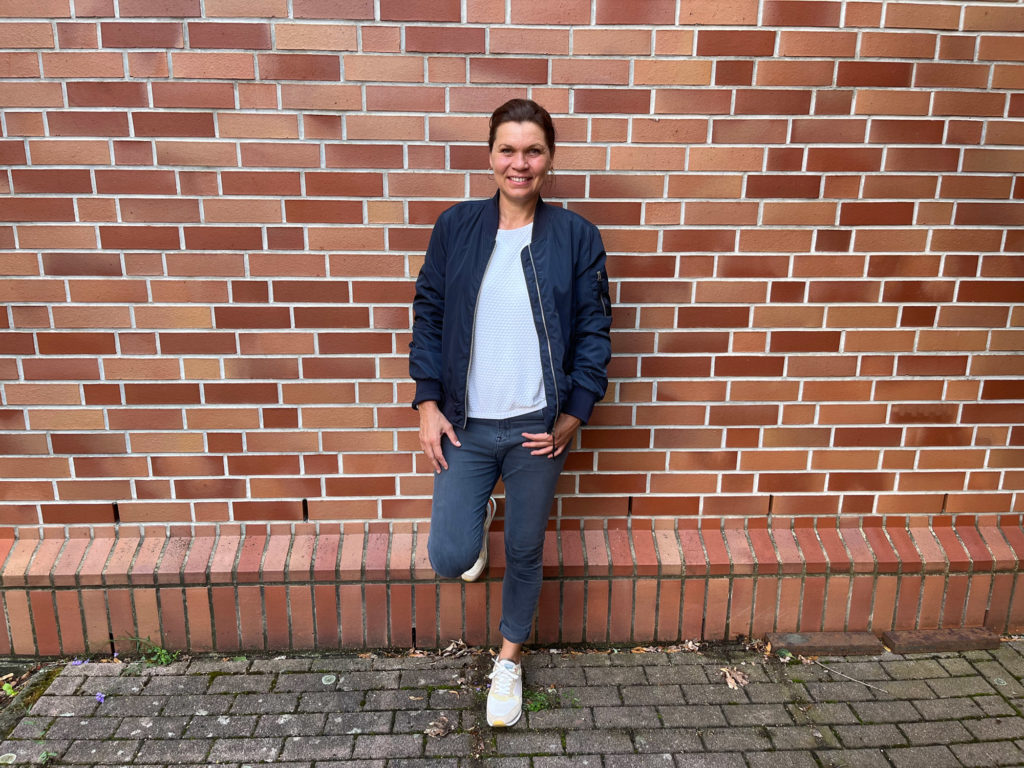 Louise Hansen stehend vor einer Hauswand